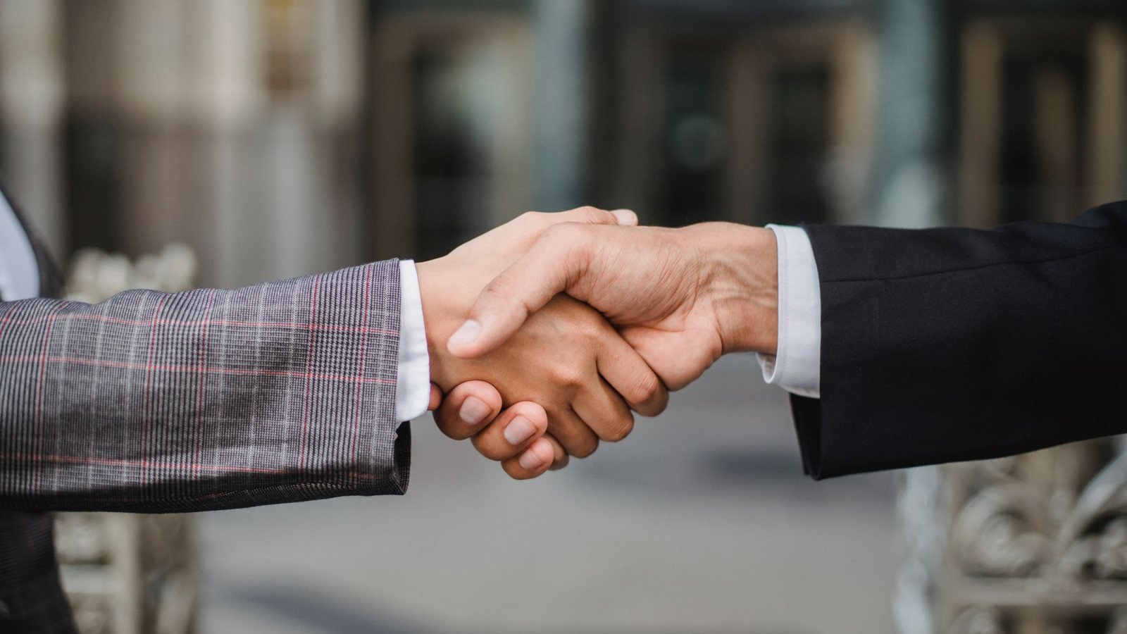 A close-up of two businesspeople shaking hands, symbolizing cooperation and partnership.